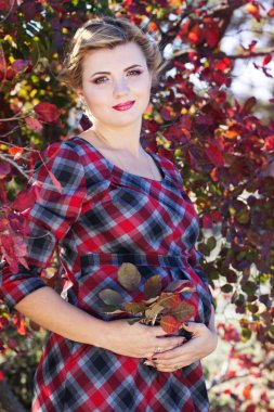 Hamile kız parkta damalı elbise giyiyor