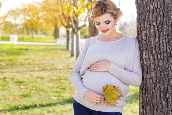 Zwangere meisje in herfst park — Stockfoto