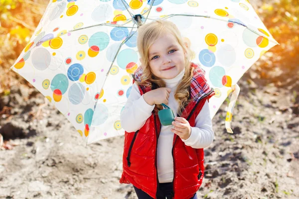 Little girl with umbrella in red vest outdoor — Stock Photo, Image
