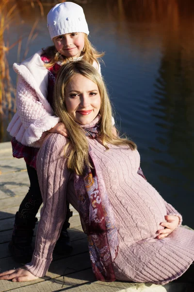 Little girl with her mother on the autumn lake — Stock Photo, Image