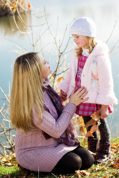Kleines Mädchen mit Mutter am Herbstsee — Stockfoto