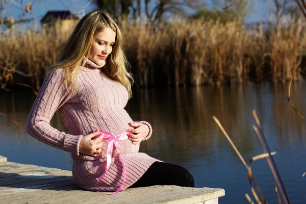 Pregnant woman on the autumn lake — Stock Photo, Image