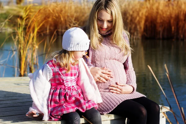 Little girl with her mother on the autumn lake — Stock Photo, Image