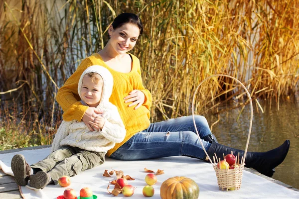 Little boy with her mother on the autumn lake — Stock Photo, Image