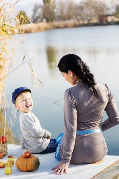 Little boy with her mother on the autumn lake — Stock Photo, Image