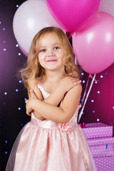 Little girl with pink balloons and gift boxes — Stock Photo, Image