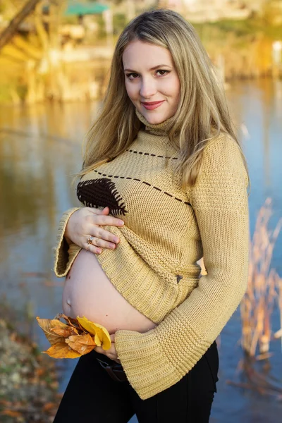 Mujer embarazada en el lago de otoño — Foto de Stock