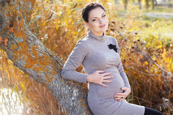 Беременная женщина на природе, осеннее время — стоковое фото