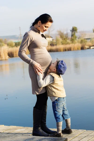 Niñito con su madre en el lago de otoño — Foto de Stock