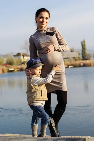 Niñito con su madre en el lago de otoño — Foto de Stock