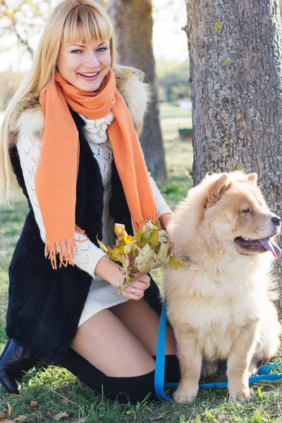 Attractive girl with her dog wearing warm clothes — Stock Photo, Image