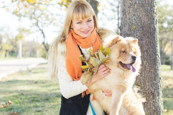 Attractive girl with her dog wearing warm clothes — Stock Photo, Image