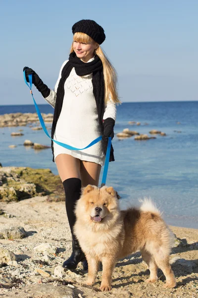 Attractive girl with her dog wearing warm clothes — Stock Photo, Image