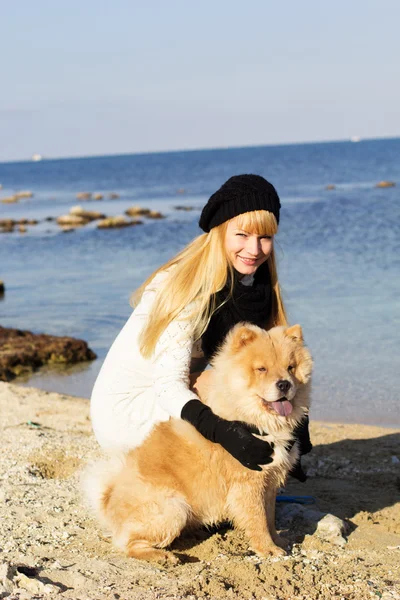 Attractive girl with her dog wearing warm clothes — Stock Photo, Image