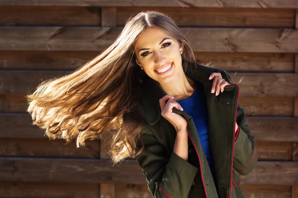 Молодая девушка моды возле деревянной стены — стоковое фото