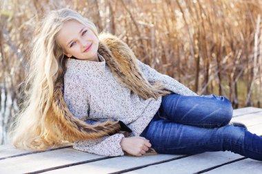 Sevimli küçük kız göl kenarında dinleniyor