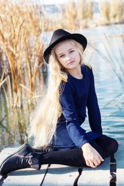 Şirin moda küçük kız göl kenarında dinleniyor