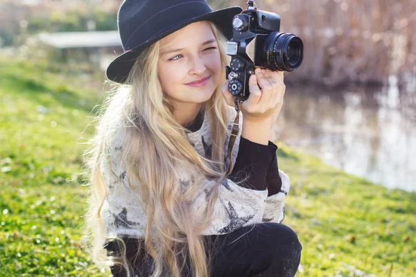 Schattig klein meisje is rust in de buurt van lake met camera — Stockfoto