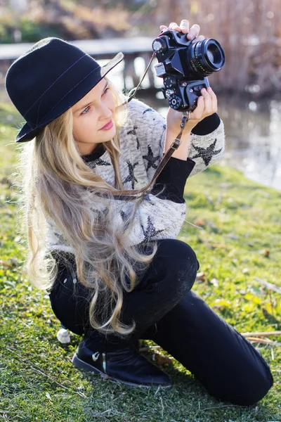 Cute dziewczynka jest odpoczynek w pobliżu jeziora z aparatu — Zdjęcie stockowe