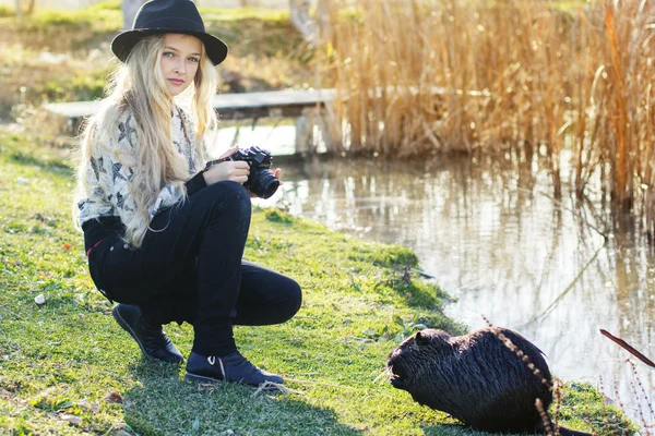 Roztomilá holčička odpočívá nedaleko jezera s fotoaparátem — Stock fotografie