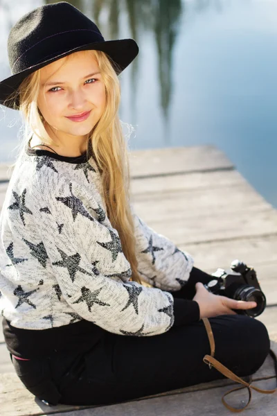 Schattig klein meisje is rust in de buurt van lake met camera — Stockfoto