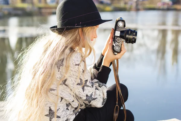 Cute dziewczynka jest odpoczynek w pobliżu jeziora z aparatu — Zdjęcie stockowe