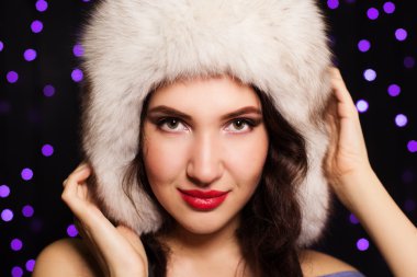 Tüylü kış şapkalı hoş gülümseyen kız