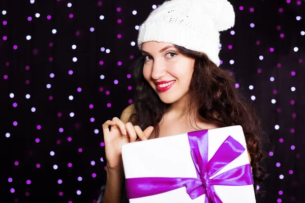 Girl holding gift box with purple ribbon — Stock Photo, Image