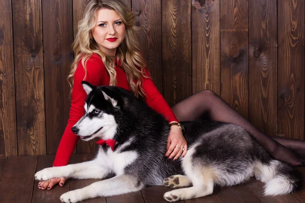 Jeune fille portant une robe rouge avec son chien husky — Photo