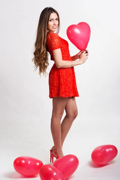 Mujer sosteniendo globos de corazón rojo —  Fotos de Stock