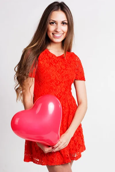 Hermosa chica está sosteniendo globos de corazón rojo — Foto de Stock