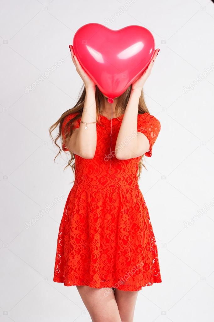 Woman holding red heart balloon