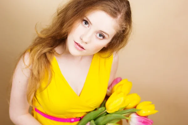 Beautiful redheared girl with bouquet of tulips — Stock Photo, Image