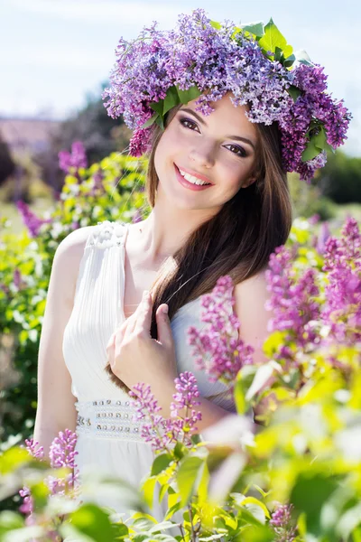 Schöne Mädchen mit einem Flieder Blumen — Stockfoto