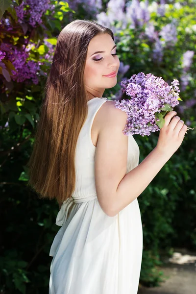 Hermosa chica con flores lila — Foto de Stock