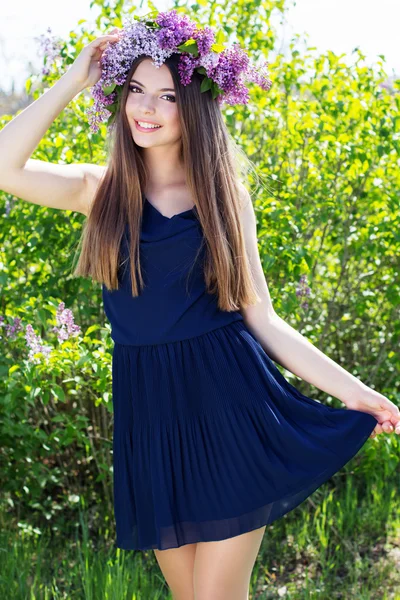 Beautiful girl with wreath of lilac flowers — Stock Photo, Image