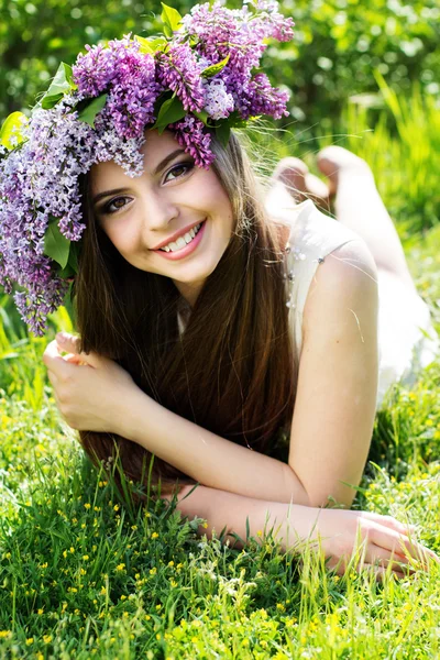 Menina bonita com grinalda de flores lilás — Fotografia de Stock