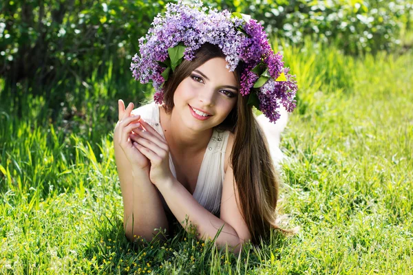 Menina bonita com grinalda de flores lilás — Fotografia de Stock