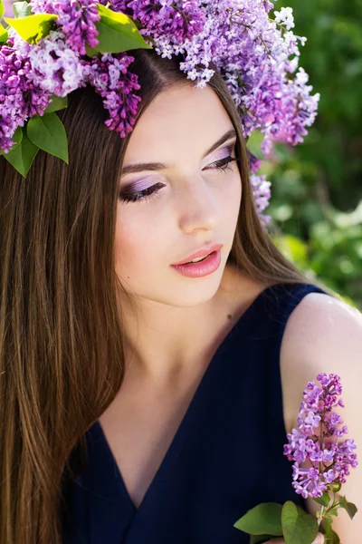 Beautiful girl with wreath of lilac flowers — Stock Photo, Image