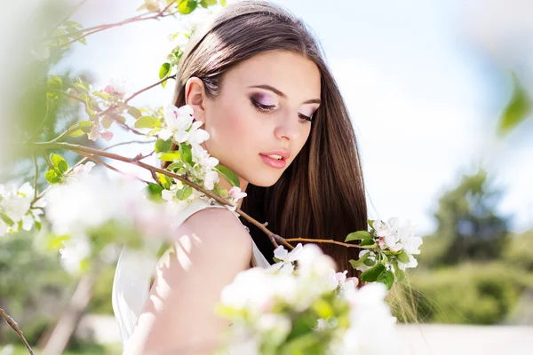 Bella ragazza in un giardino di fiori di ciliegio — Foto Stock