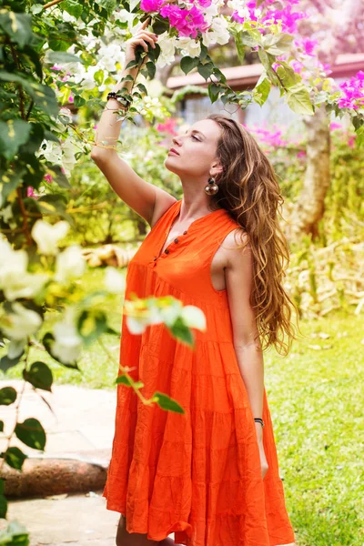 Vacker kvinna i park med blommor — Stockfoto