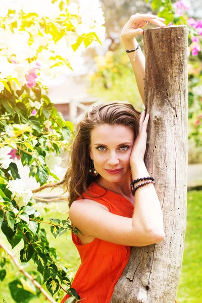 Mujer bonita en el parque con flores — Foto de Stock