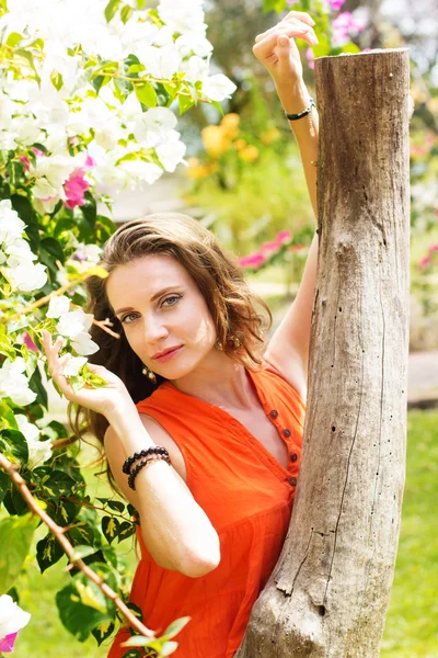 Mulher bonita no parque com flores — Fotografia de Stock