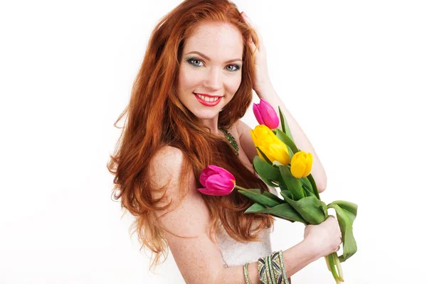 Redheaded smiling girl is holding tulips — Stock Photo, Image