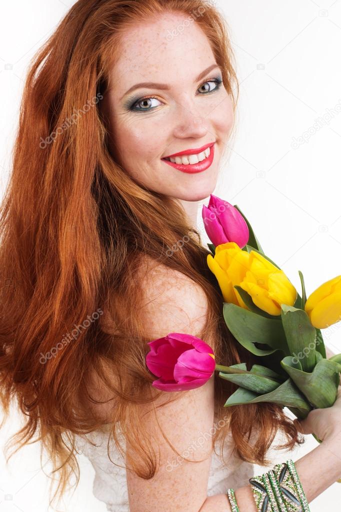 Beautiful redheaded girl is holding tulips