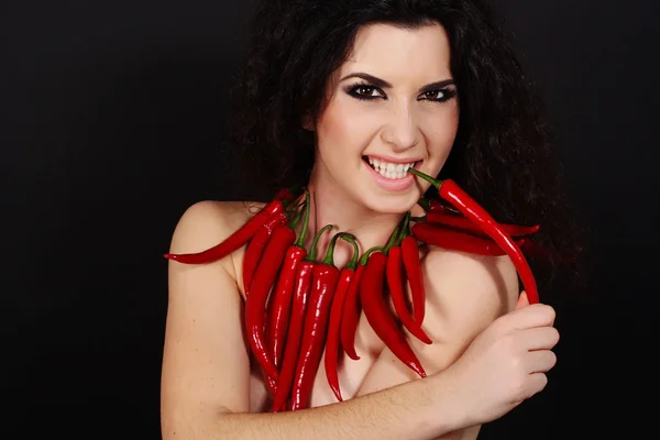 Το σέξι κορίτσι μελαχρινή με κόκκινες καυτερές πιπεριές — Φωτογραφία Αρχείου