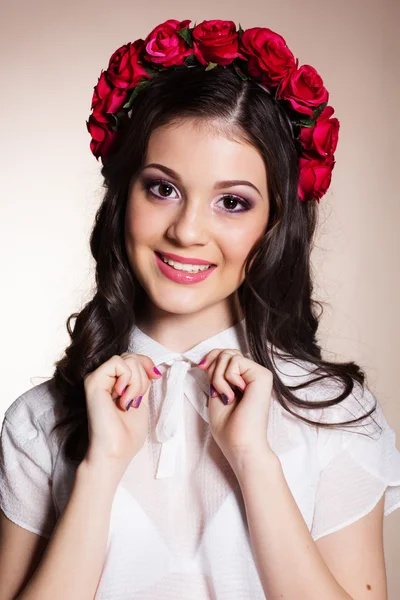 Menina adolescente morena com coroa de rosas vermelhas — Fotografia de Stock