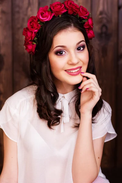 Bonita adolescente con corona de rosas rojas —  Fotos de Stock