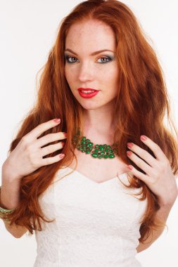 Kızıl saçlı kız yeşil kolye giyiyor