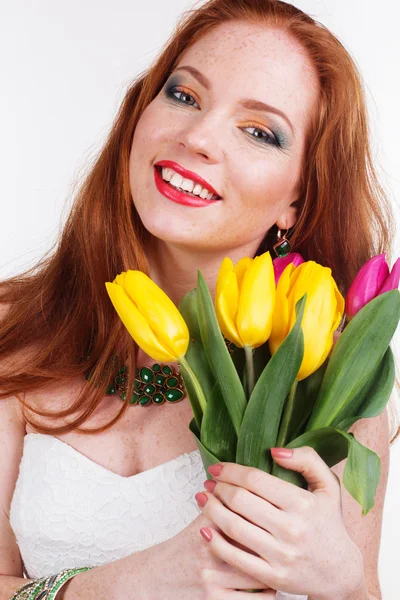 Beautiful redheaded happy girl is holding tulips — Stock Photo, Image